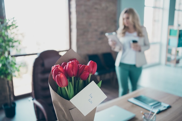 Foto del mazzo rosso fresco dei tulipani della signora bionda di affari