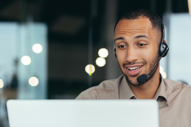 Foto del primo piano che impara online un giovane studente afroamericano bello sta studiando a distanza da a