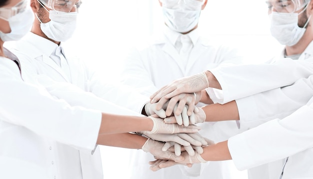 Foto del primo piano dei medici che impilano la mano con i colleghi