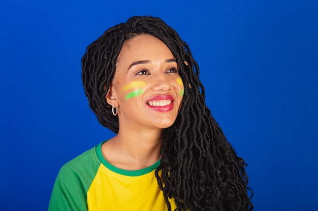 Foto del primo piano del tifoso di calcio della giovane donna brasiliana nera dei denti sorridenti