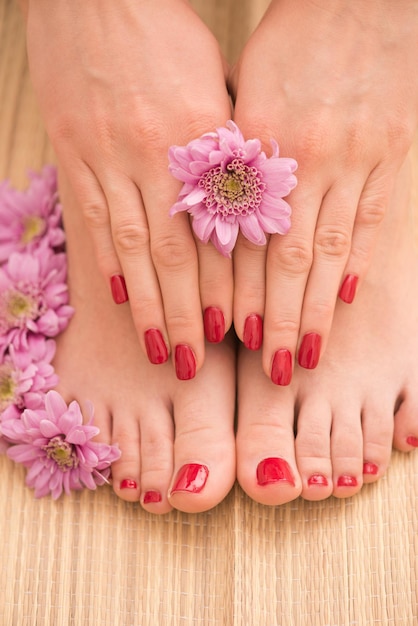 Foto del primo piano di una femmina di piedi e mani al salone termale sulla procedura di pedicure e manicure