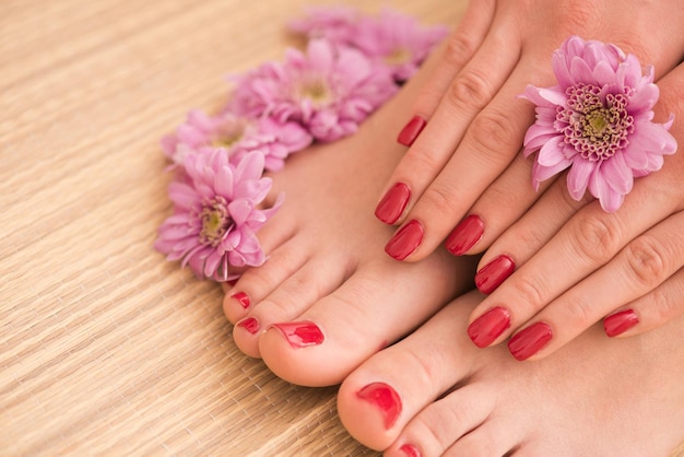 Foto del primo piano di una femmina di piedi e mani al salone termale sulla procedura di pedicure e manicure