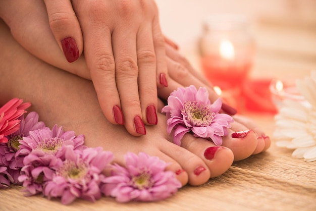 Foto del primo piano di una femmina di piedi e mani al salone termale sulla procedura di pedicure e manicure