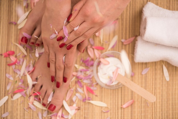 Foto del primo piano di una femmina di piedi e mani al salone termale sulla procedura di pedicure e manicure