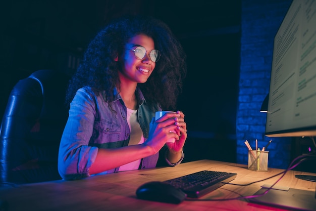 Foto del profilo della signora di affari guarda il lavoro straordinario del monitor bere caffè caldo