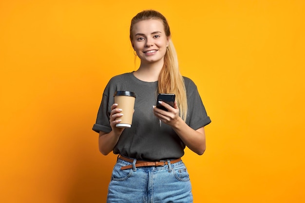 Foto dell'amica piuttosto dolce riccia positiva allegra che tiene la tazza di caffè sorridente a trentadue denti isolata sopra fondo di colore vivido