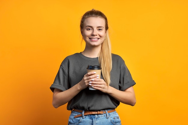 Foto dell'amica piuttosto dolce riccia positiva allegra che tiene la tazza di caffè sorridente a trentadue denti isolata sopra fondo di colore vivido