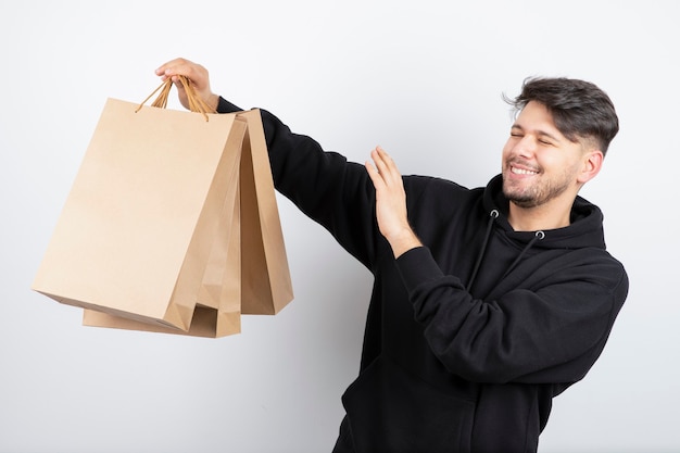 Foto dell'uomo bello in felpa con cappuccio nera che mostra la borsa del mestiere