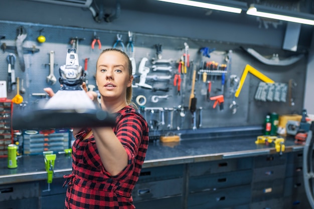 Foto della donna del meccanico che ripara uno sci nell&#39;officina