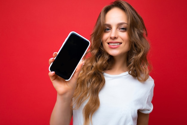 Foto della giovane donna sorridente bella in piedi vestito alla moda casual da portare isolata