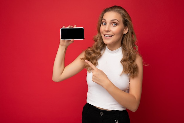 Foto della giovane donna sorridente bella in piedi vestito alla moda casual da portare isolata