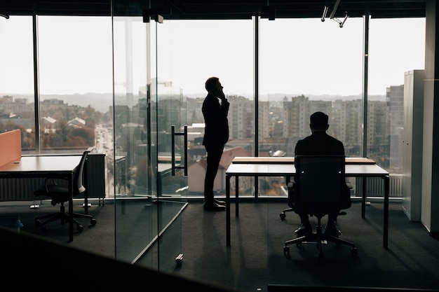Foto della silhouette di uomini d'affari durante la giornata lavorativa nella moderna sala riunioni
