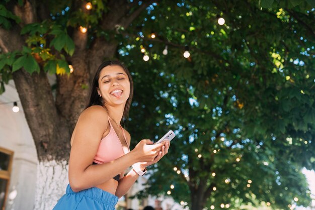 Foto di affascinante bella giovane donna che comunica gadget moderno