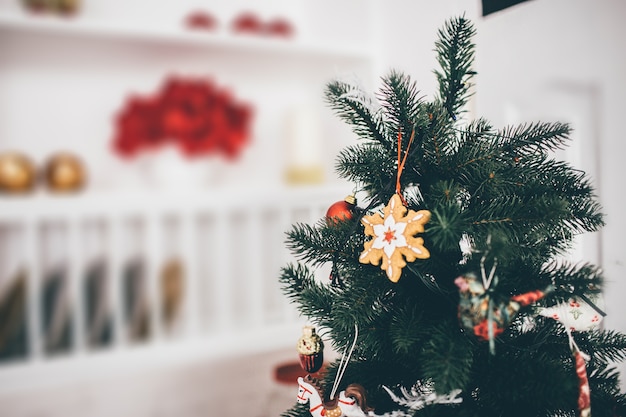 Foto di albero di Natale con decorazioni su di esso in camera bianca. Sfondo sfocato.