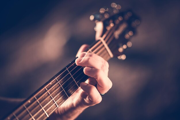 Foto di apprendimento della chitarra acustica con le mani sullo strumento a corda