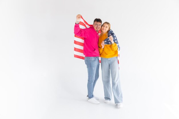 Foto di attraente coppia multietnica uomo e donna avvolti nella bandiera americana