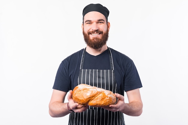 Foto di barbuto chef uomo tenendo il pane e guardando la telecamera