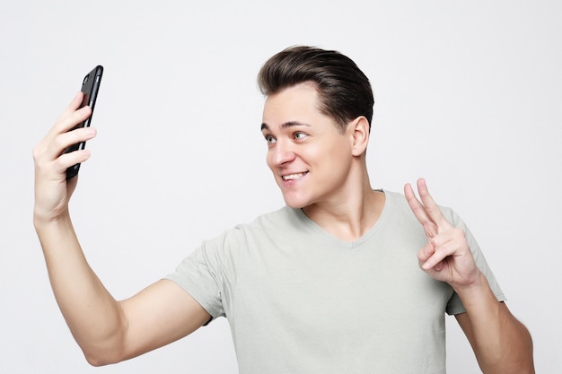 Foto di bell'uomo sorridente sulla fotocamera che scatta selfie