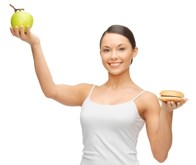 foto di bella donna con hamburger e mela