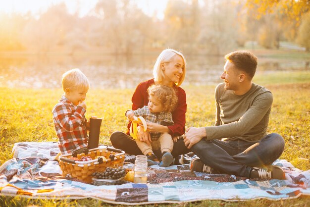 Foto di bella famiglia, picnic nel weekend, sorridente e godendo del tempo insieme