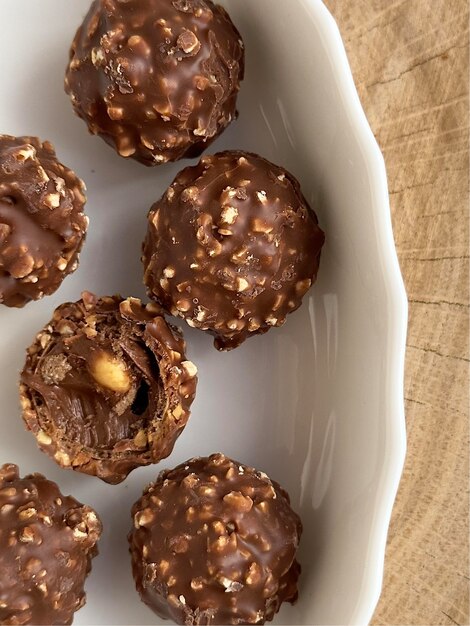 Foto di caramelle croccanti al cioccolato con noci su un piatto bianco.