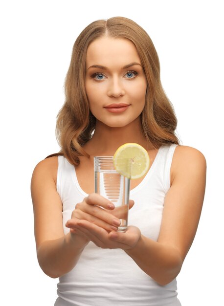 foto di donna con fetta di limone su un bicchiere d'acqua.