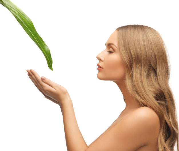 foto di donna con foglia verde su bianco.