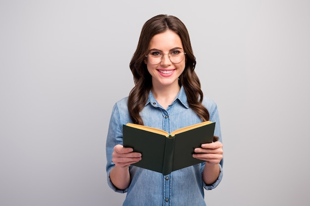 Foto di donna d'affari piuttosto divertente tenere il libro mani lettore toothy raggiante sorridente buon umore specifiche di usura jeans casual camicia di jeans isolato colore grigio