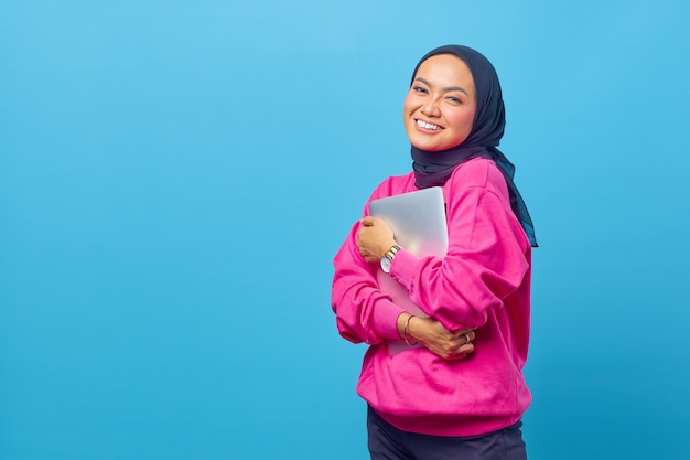 Foto di donne in Asia che tengono il laptop indossano un maglione rosa