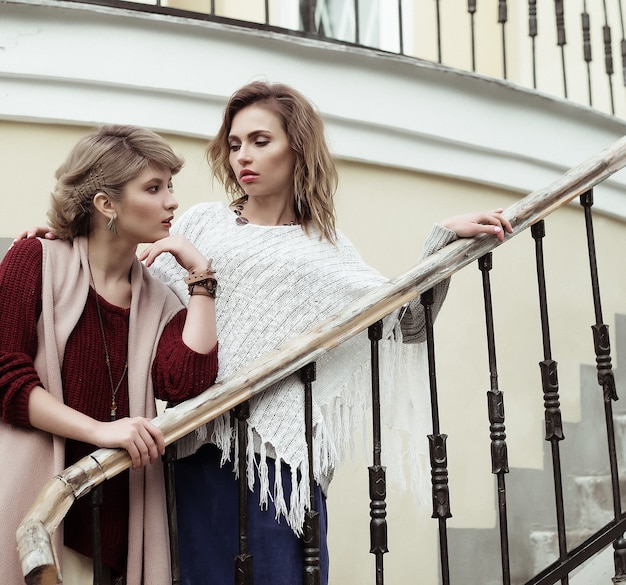 Foto di due belle donne in posa su una scala