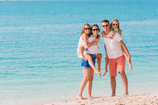 Foto di famiglia felice che si diverte sulla spiaggia. Stile di vita estivo