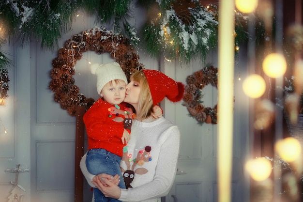 Foto di famiglia per la mamma di Natale con la figlia piccola vicino a scatole rosse per le vacanze