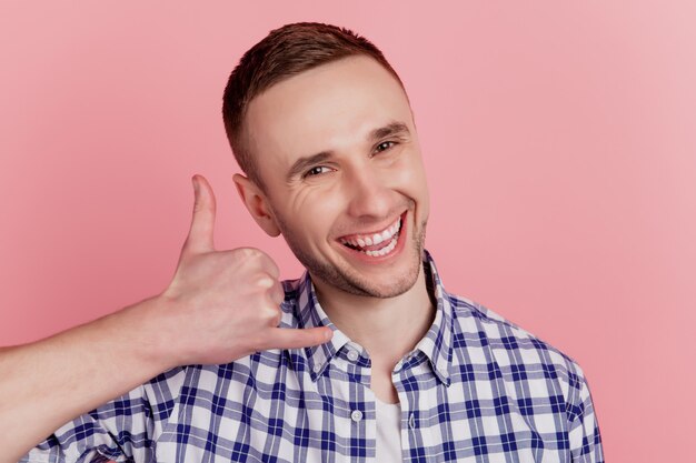 Foto di felice sorriso positivo uomo mi fa chiamare gesto telefono parlare dire isolato su sfondo di colore rosa