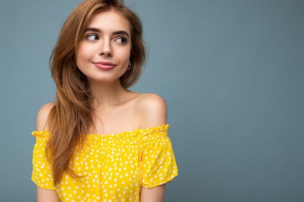 Foto di giovane bella donna bionda carina con emozioni sincere isolata sulla parete di fondo con