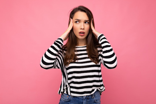 Foto di giovane donna bruna carina affascinante stanca sconvolta triste con emozioni sincere che indossa pullover a righe casual