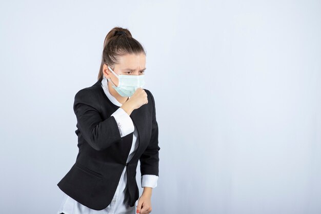 Foto di giovane donna in maschera tosse su sfondo bianco. Foto di alta qualità