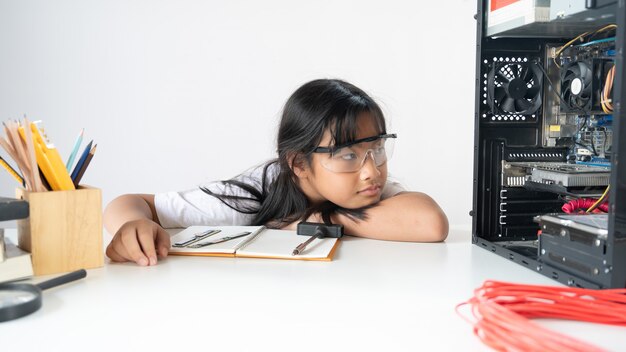 Foto di giovane ragazza adorabile che esamina l'hardware e gli accessori di computer