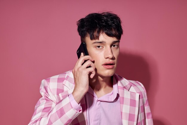 Foto di giovane ragazzo romantico con un telefono in mano blazer rosa moda stile elegante Stile di vita inalterato