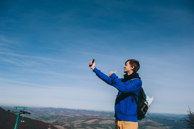 Foto di giovani prendendo da smart-phone sulla cima della montagna