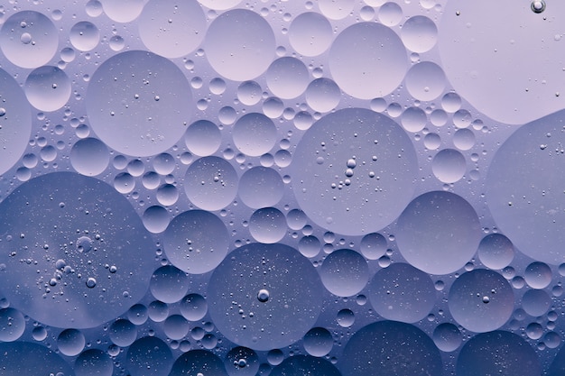 Foto di macro fondo astratto della bolla dell'olio di acqua, liquido di flusso nei colori blu, porpora, bianco scuro, aqua