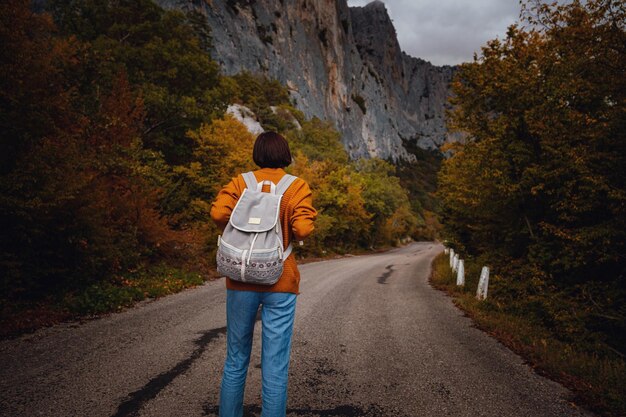 Foto di moda all'aperto di giovane bella signora circondata dalla foresta autunnale in montagna