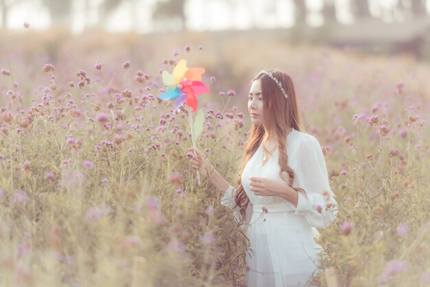 Foto di moda all'aperto di giovane bella signora nel paesaggio autunnale con fiori secchi.