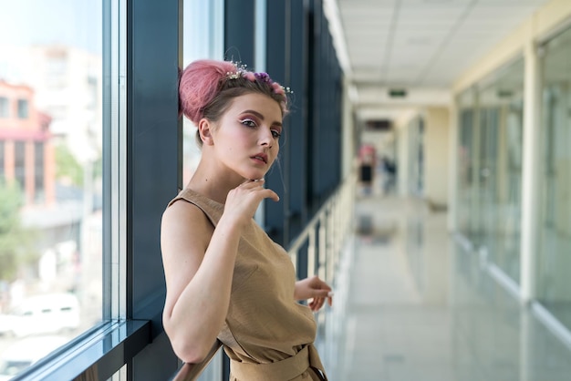 Foto di moda di una giovane donna con acconciatura rosa e trucco fresco