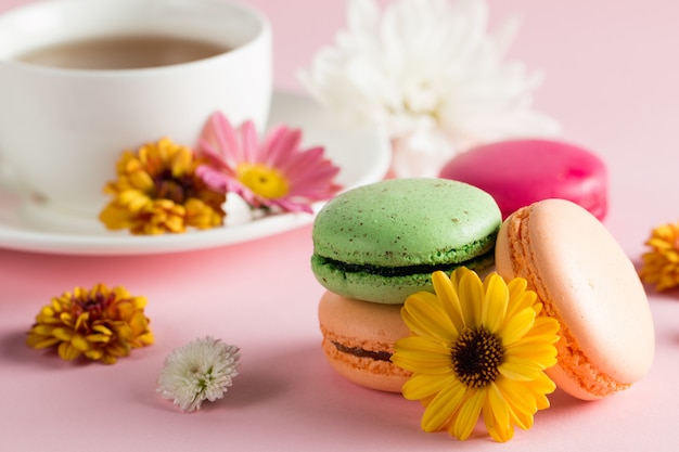 Foto di natura morta e cibo di macarons torta in una confezione regalo con fiori, una tazza di tè