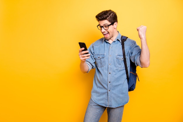 Foto di nerd elegante alla moda allegro alla moda vedendo i suoi esami che sono stati superati con un eccellente mart in jeans denim isolato muro di colori vivaci