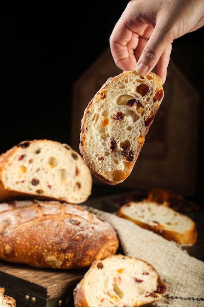 Foto di pane d'epoca pane di grano crudo originale Una mano raggiunge un pezzo di pane