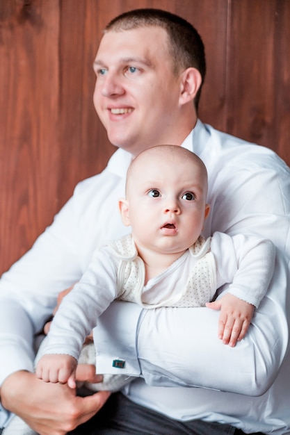 Foto di papà con il figlio in posa su sfondo di legno