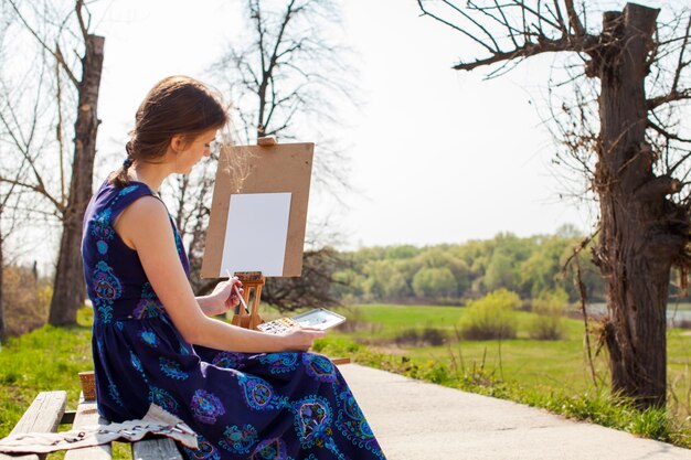 Foto di pittura giovane artista femminile nel parco di primavera