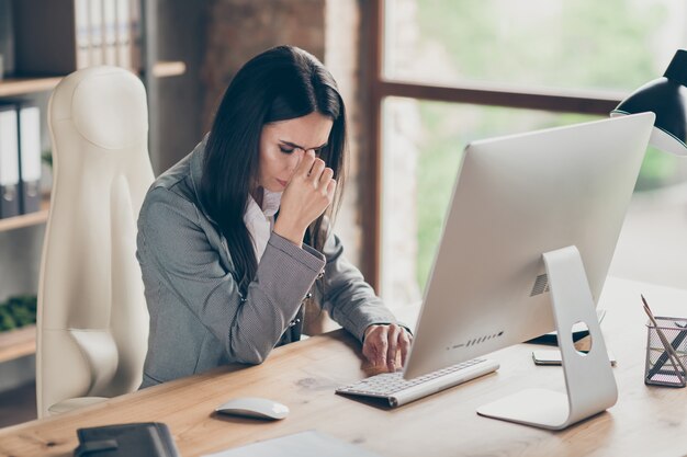 Foto di ragazza frustrata avvocato agente collare sedersi scrivania tavolo ottenere pc computer social network perdita di lavoro covid quarantena crisi notifica toccare naso dita indossare blazer in ufficio moderno