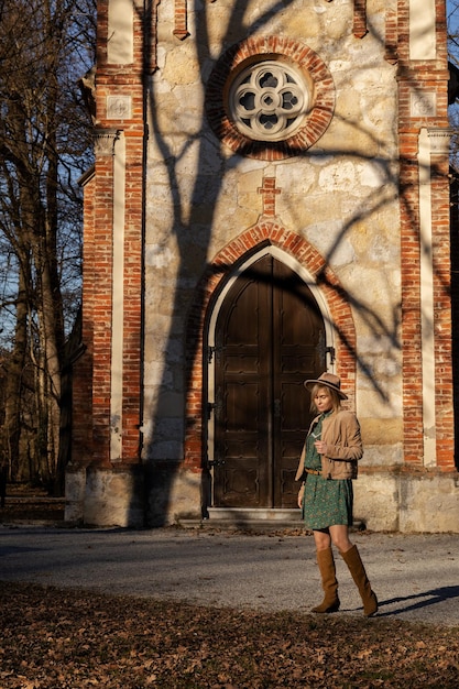 Foto di ragazza in stile boho sullo sfondo della cappella del Medioevo